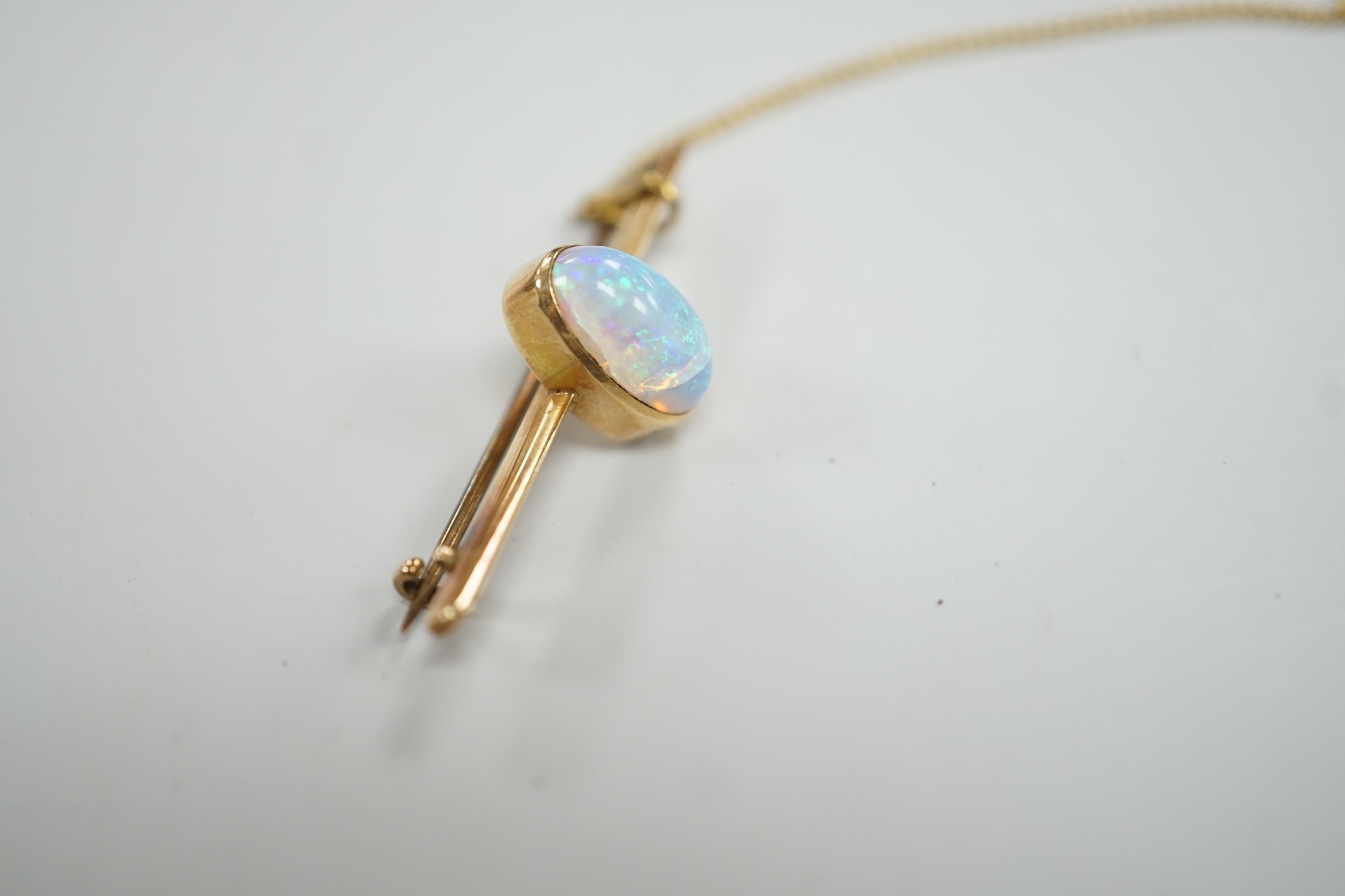 A yellow metal and single stone oval white opal set bar brooch, 39mm, gross weight 4.3 grams.